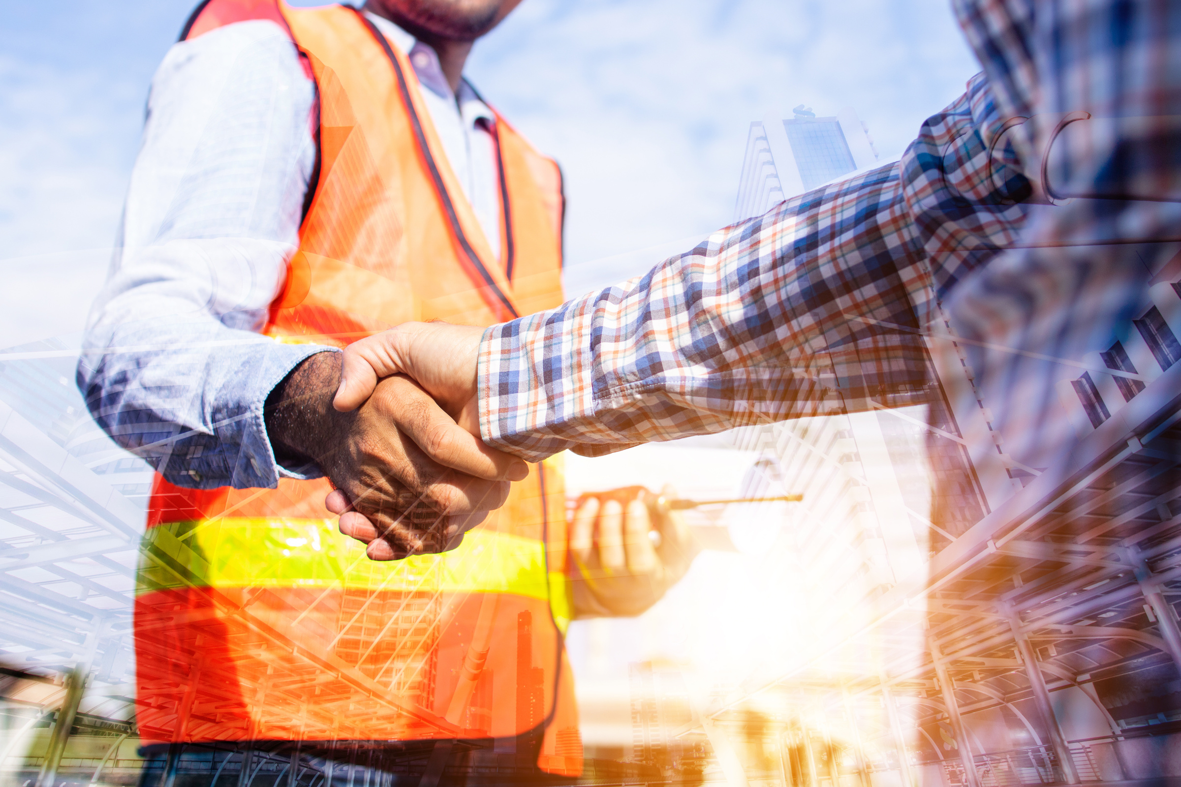 Architect contractor shaking hands with client at construction site